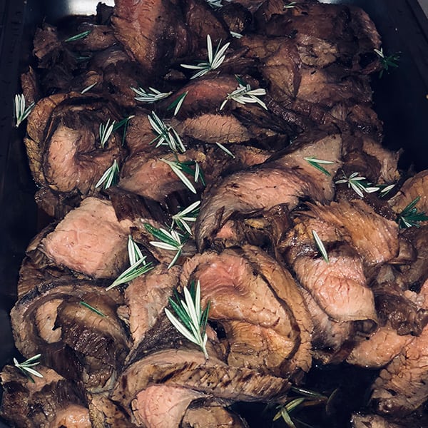 A close up of meat with herbs on it