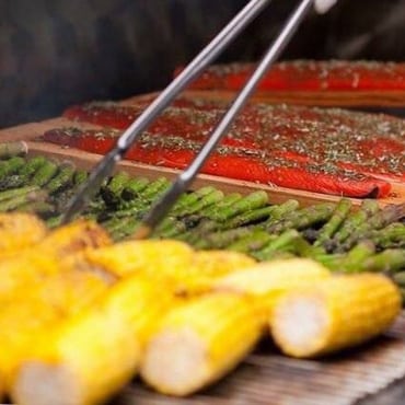 A grill with corn and asparagus on it.