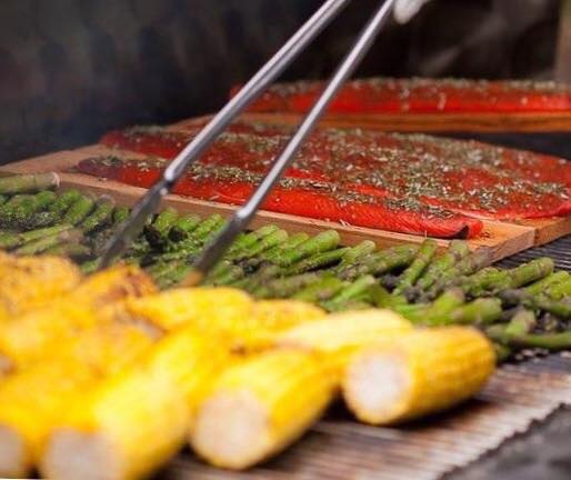 A grill with corn on the cob and asparagus.